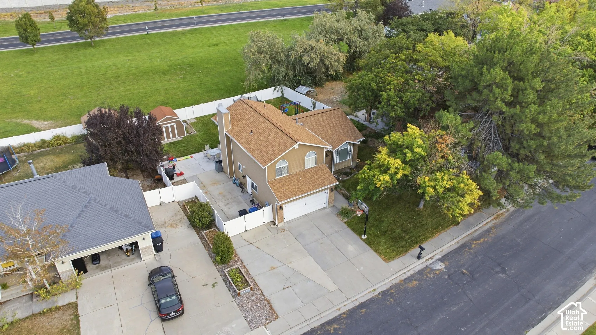 Two-story residence with an attached garage, featuring a shingle roof and a paved driveway
