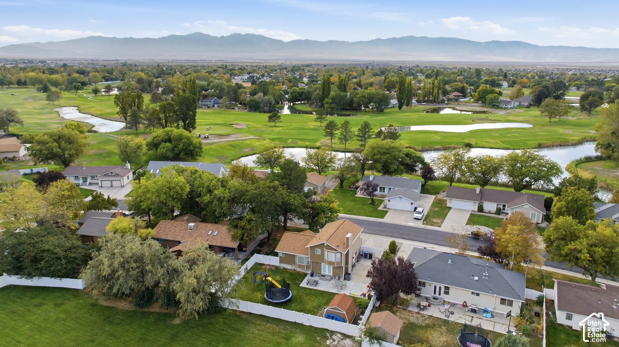 Aerial view showcasing a substantial residential property with manicured landscaping, mature trees, and multiple outbuildings on expansive grounds