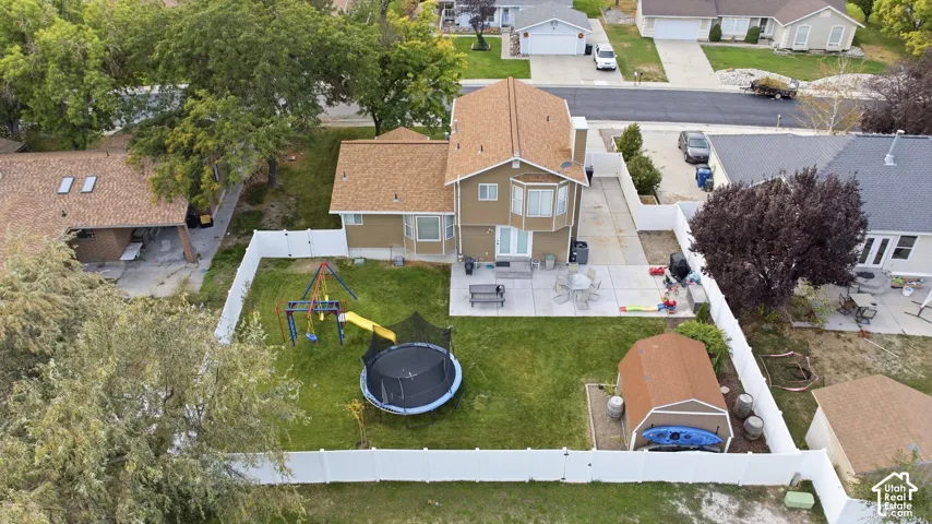 Spacious backyard with a large lawn area, privacy fencing, and a concrete patio