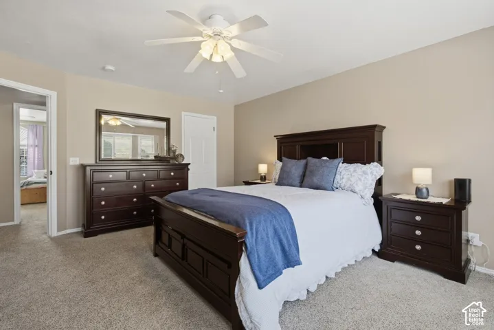 Carpeted flooring, neutral wall tones, and a ceiling fan with integrated lighting