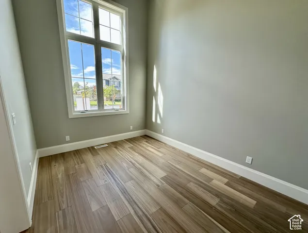 Expansive window with white trim, wood-finish flooring, light-toned walls, and white electrical outlets
