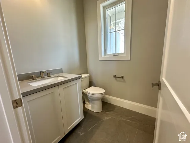 White shaker-style vanity with a quartzite countertop and an under mount sink