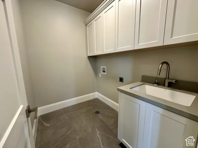 Integrated utility sink with a brushed nickel faucet, light quartzite countertop, and white shaker-style cabinetry