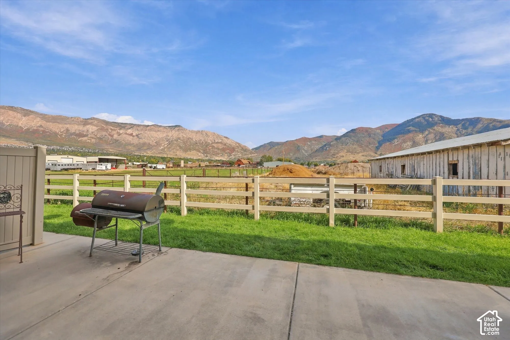 Concrete patio with a grassy expanse and mountain backdrop