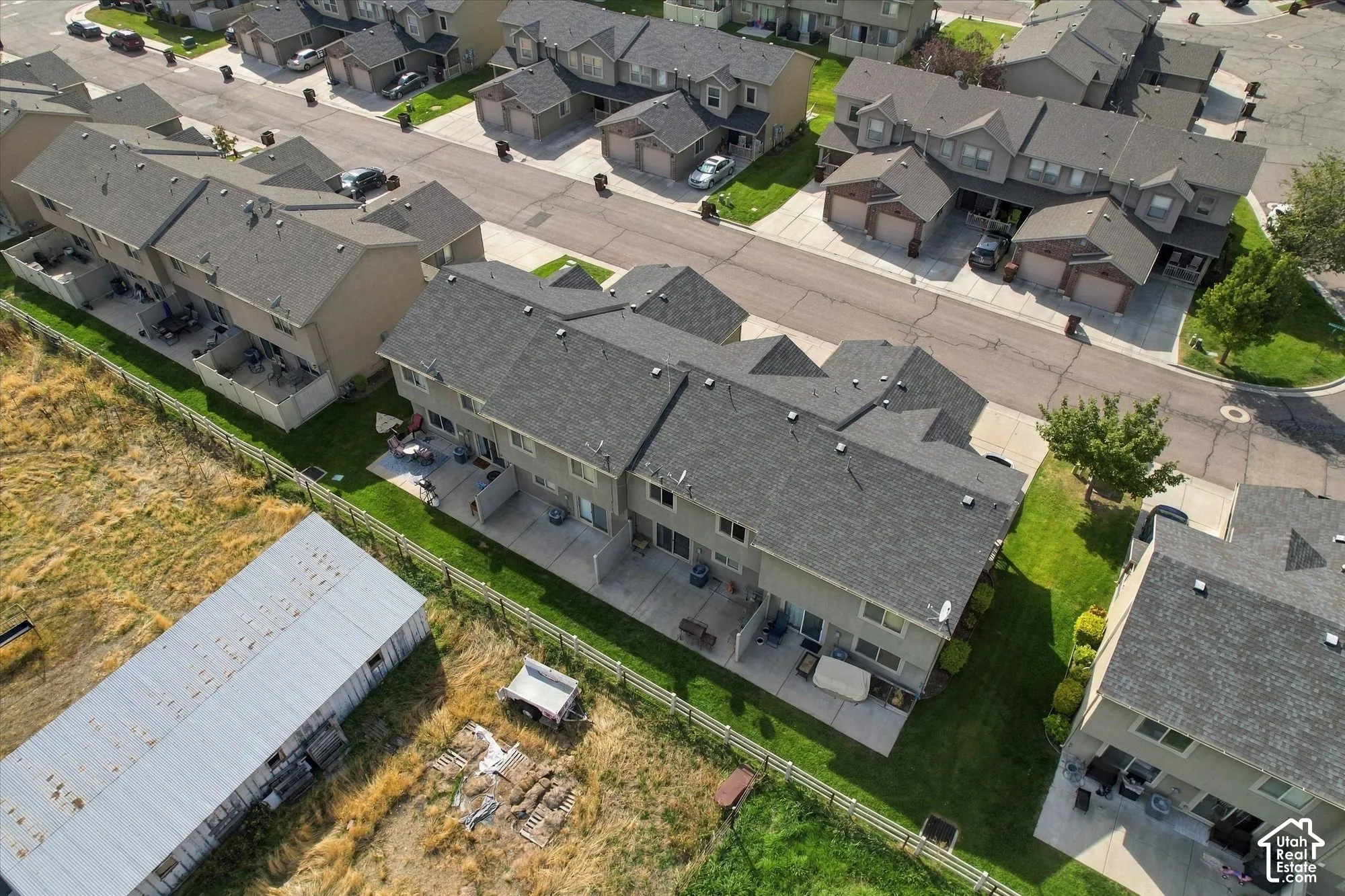 Townhome community featuring consistent roofing, private patios, and individual garages