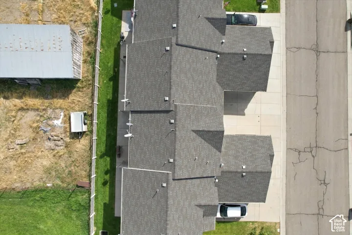 Asphalt shingle roofing, paved driveways, and a manicured lawn