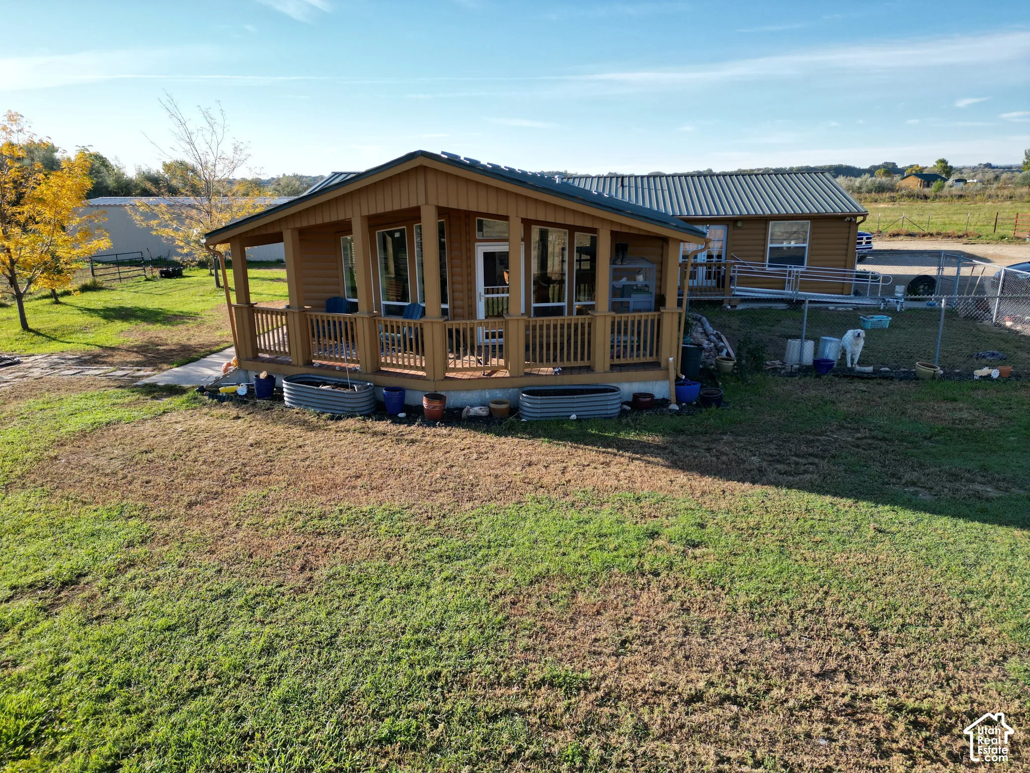 Wood-sided exterior featuring an elevated covered porch with wood railings and a metal roof