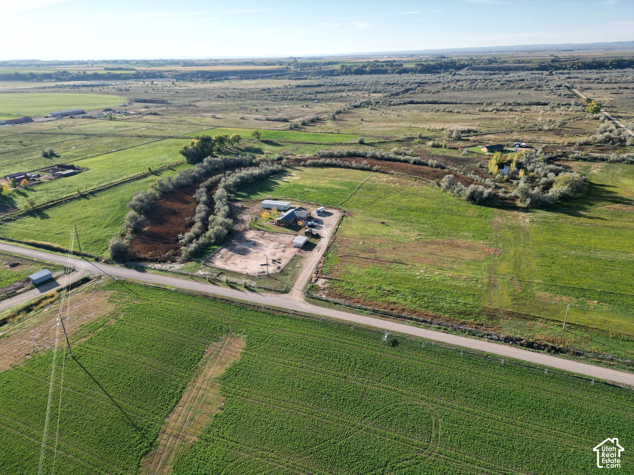 Expansive land with multiple structures and surrounding natural areas