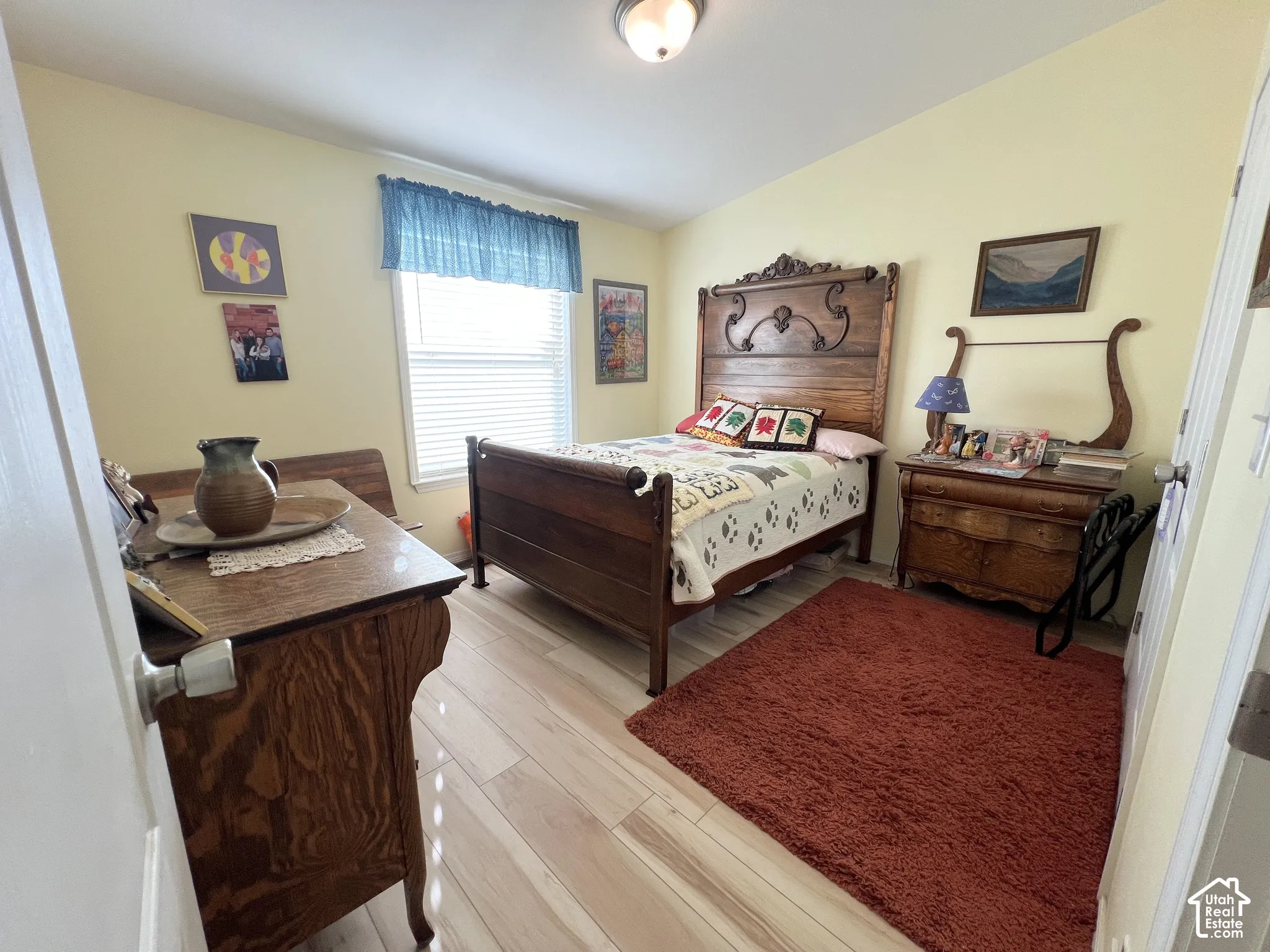 Wood-finish flooring with light-toned walls and a single window with blinds