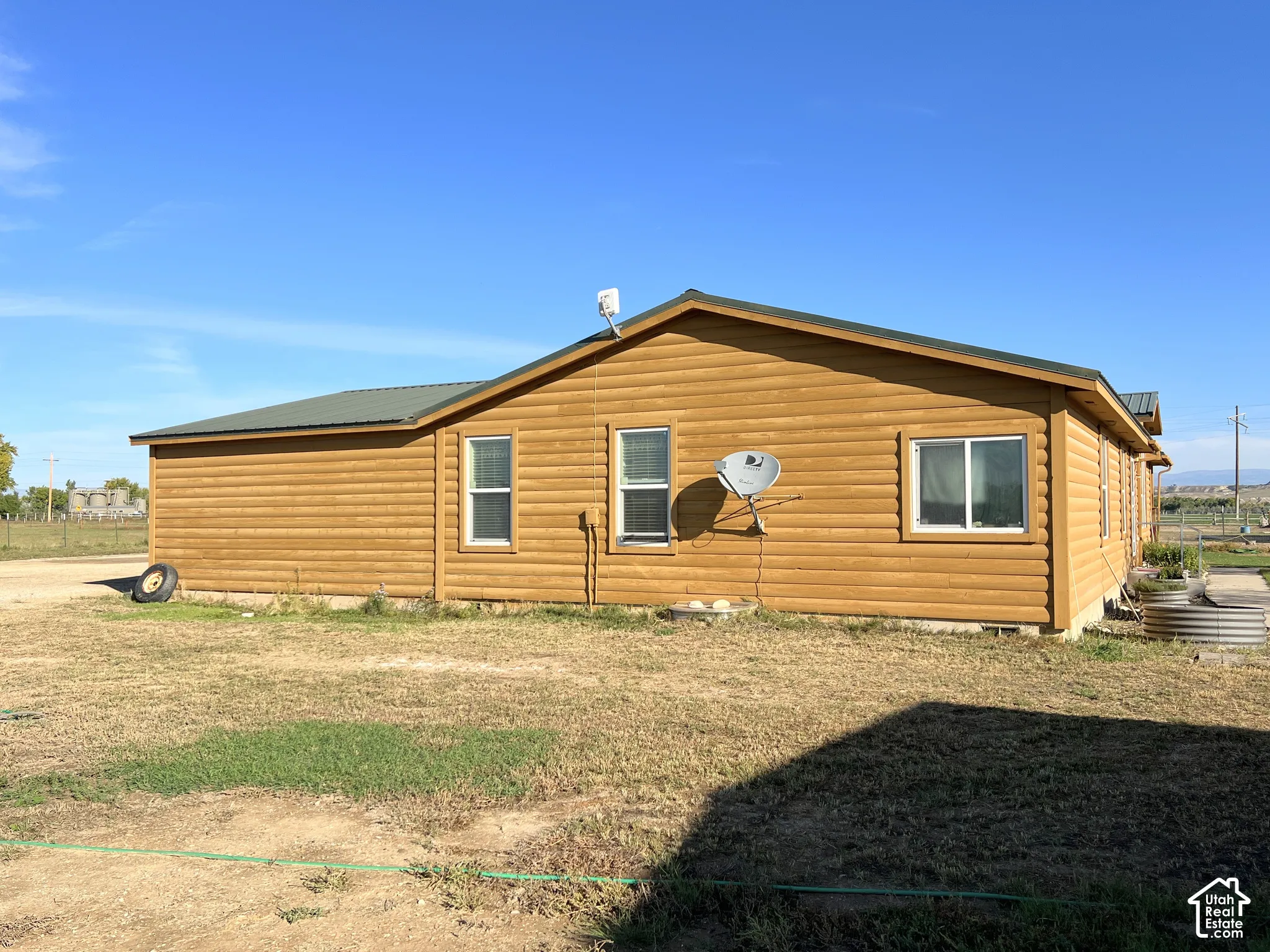 Wood-finish siding with white-framed windows and a dark-colored roof