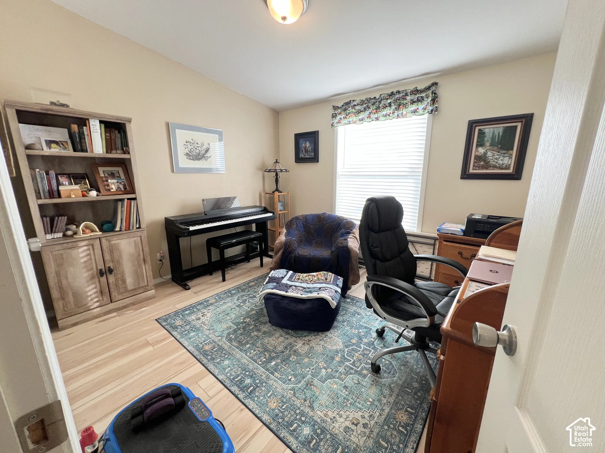 Light wood-finish flooring, neutral wall tones, and a single window with blinds