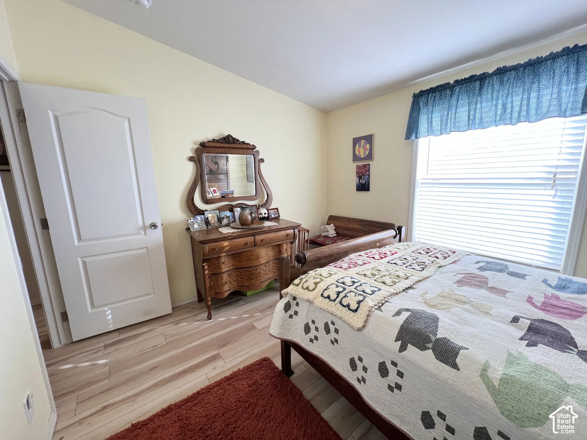 Wood-finish flooring, light-colored wall paint, and a bright window with blinds