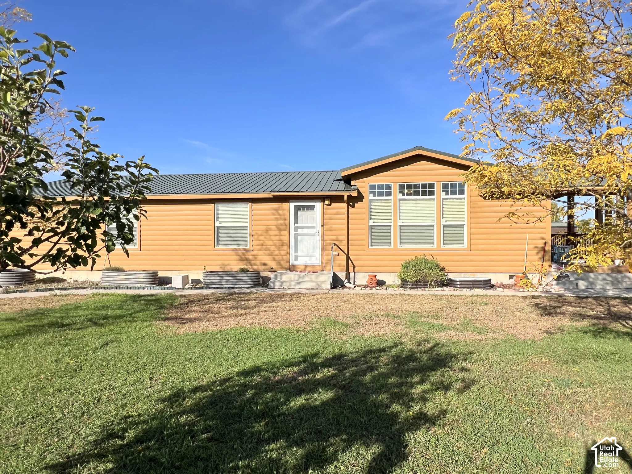 Siding exterior with a metal roof and multiple windows