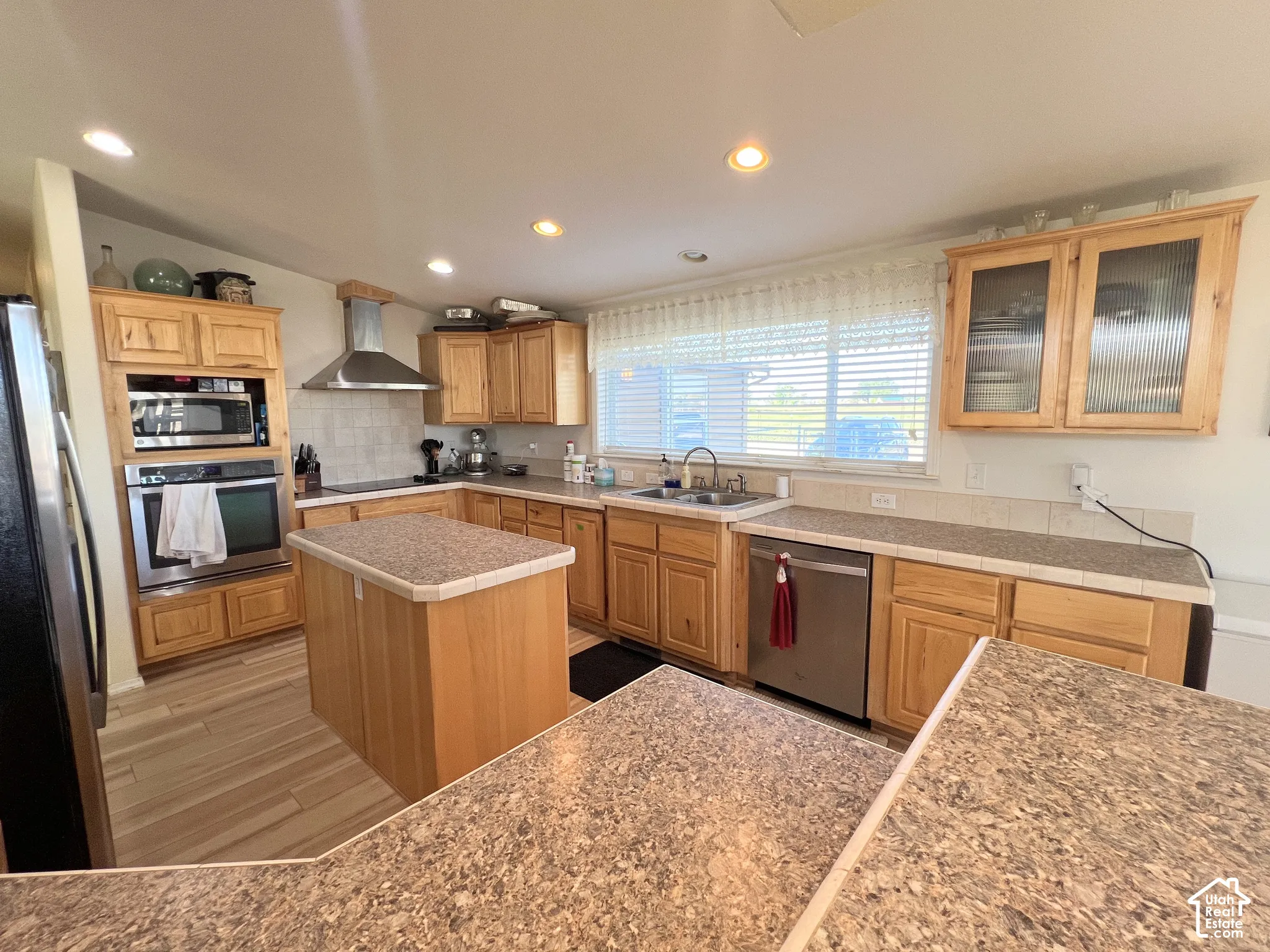Kitchen featuring wood cabinetry, stainless steel appliances, a center island, and recessed lighting