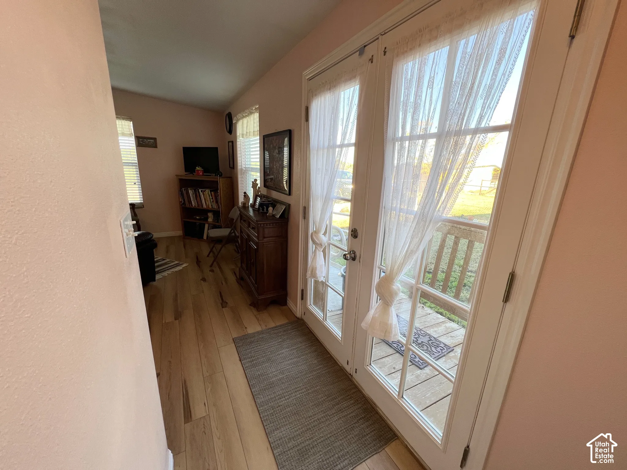 French doors with multiple panes of glass, wood-finish flooring, and a window with horizontal blinds