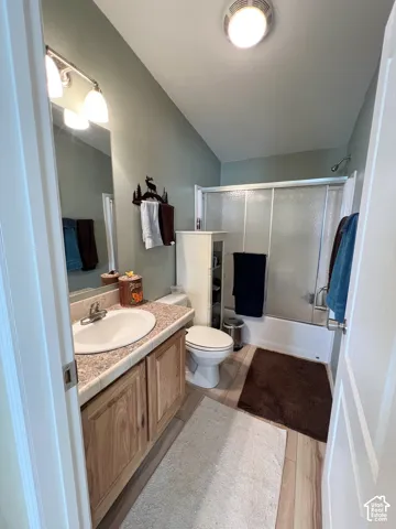 Light wood-finish flooring with a vanity featuring a drop-in sink and light-toned countertop