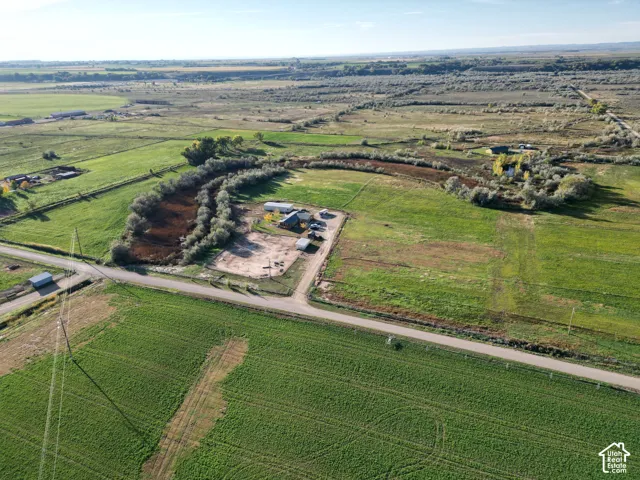 Expansive land with multiple structures and surrounding natural areas