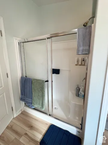 Walk-in shower with clear glass sliding doors, integrated bench seating, and a fixed shower head