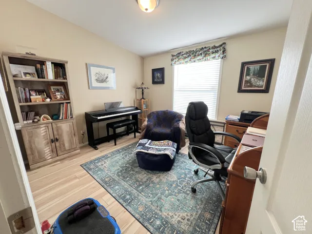 Light wood-finish flooring, neutral wall tones, and a single window with blinds