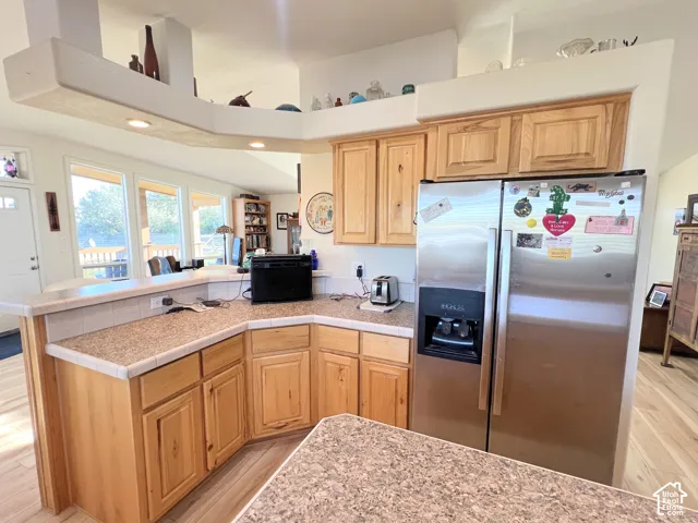 Wood-finish cabinetry paired with granite-style countertops and a tile backsplash