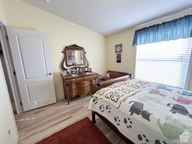 Wood-finish flooring, light-colored wall paint, and a bright window with blinds