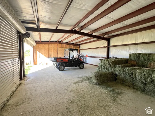 Metal-framed structure with a roll-up door, concrete flooring, and insulated paneling