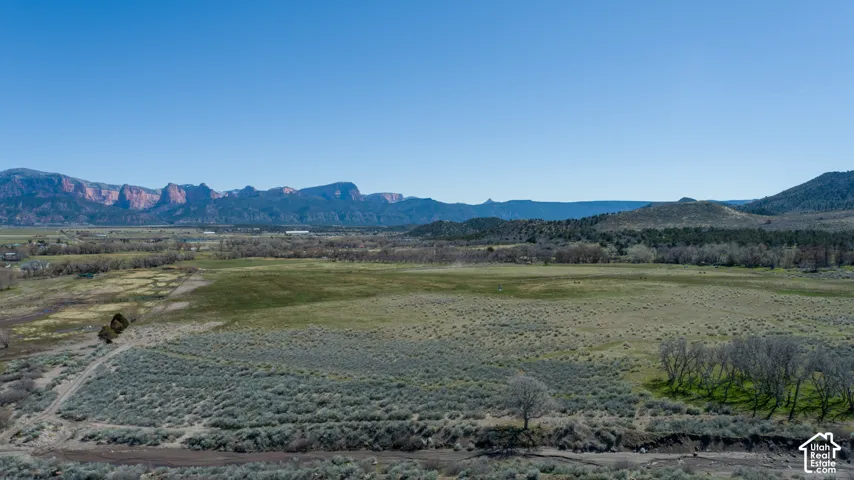 Expansive undeveloped land featuring natural terrain and distant mountains