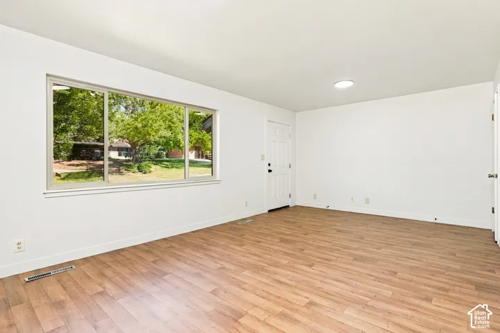 Expansive window, recessed ceiling lighting, wood-finish flooring, white walls, white doors