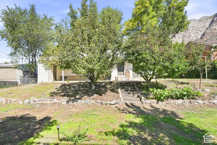 Tiered landscaping featuring stone retaining walls and mature trees