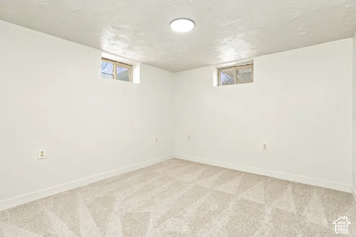 Recessed ceiling light fixture, two transom windows, light-toned carpet flooring, white walls