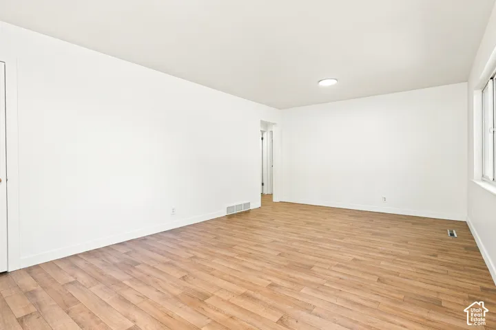 Wood-finish flooring, white walls, and a ceiling-mounted light fixture
