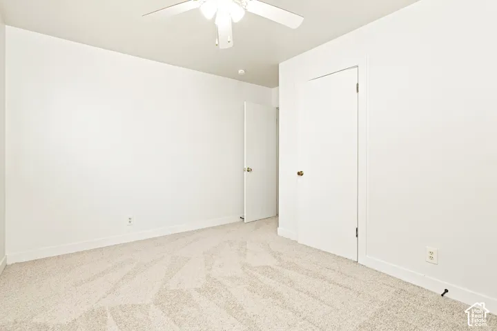 Room with light-toned patterned carpeting and white walls