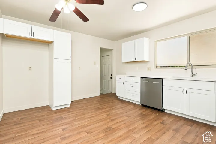 White cabinetry, wood-finish flooring, stainless steel dishwasher, ceiling fan, and recessed lighting