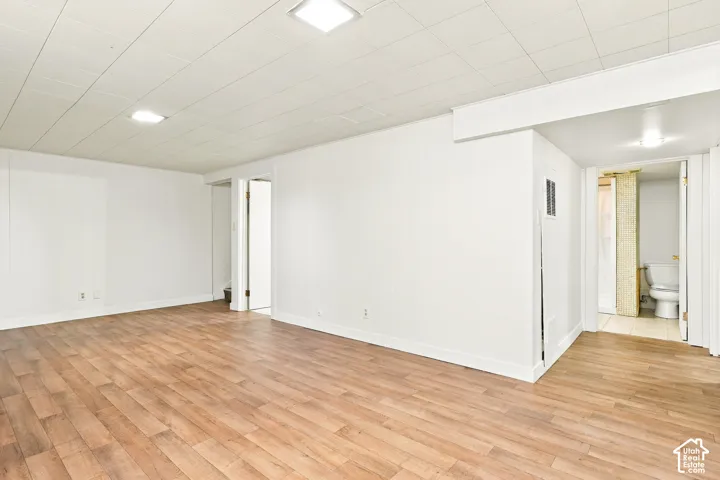 Wood-finish flooring with white walls and a drop ceiling