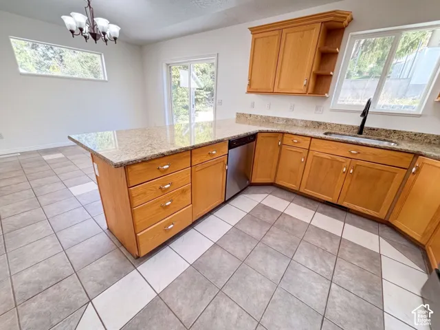 Kitchen featuring wood cabinetry, granite-style countertops, stainless steel appliances, and tile flooring