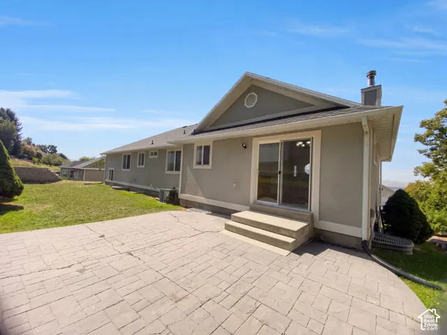 Stamped concrete patio with integrated steps, sliding glass door access, and stucco exterior
