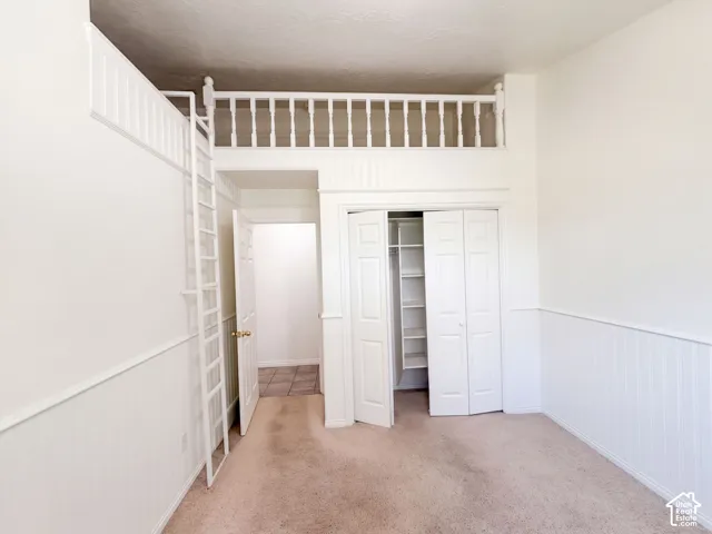 Built-in loft with ladder access, interior closet with shelving, and wainscoting paneling