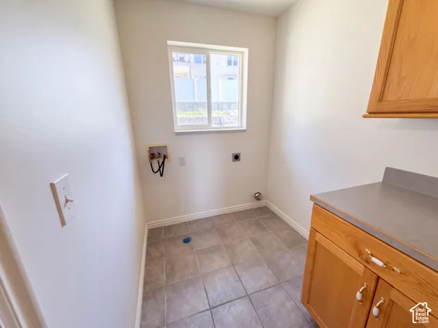 Tile flooring with light wood-finish cabinetry and a complementary countertop