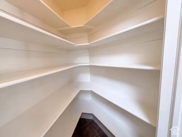Built-in shelving with multiple levels, white finish, and tile flooring
