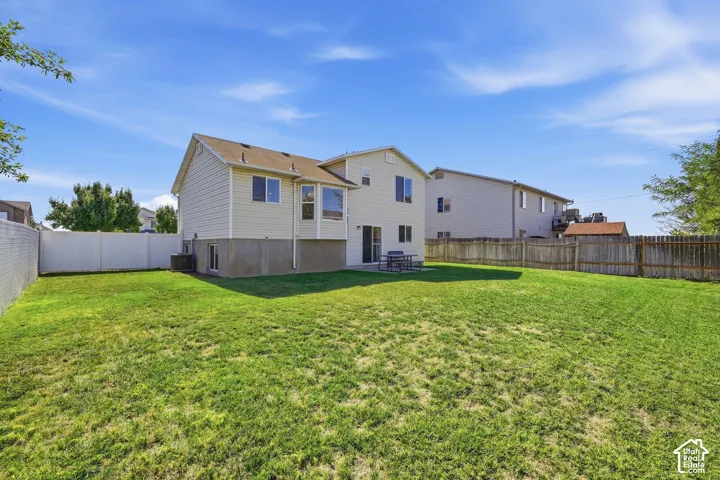 Expansive backyard featuring a manicured lawn, a concrete patio, and a privacy fence