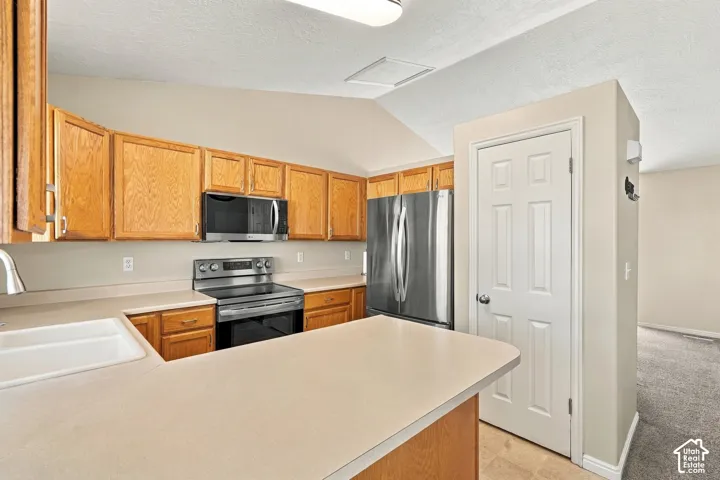 Kitchen featuring wood cabinetry, stainless steel appliances, a built-in microwave, and a double basin sink