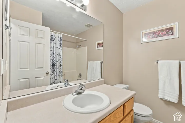 Vanity with an integrated sink, polished chrome faucet, and a large wall-mounted mirror
