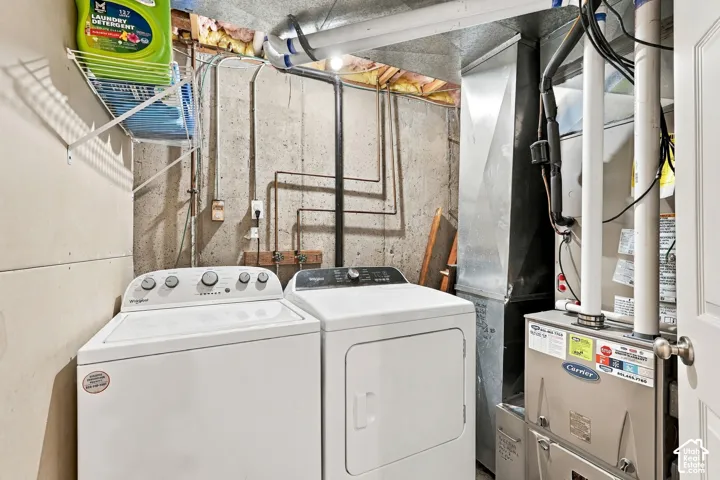 Dedicated utility area featuring a washing machine, dryer, and Carrier furnace