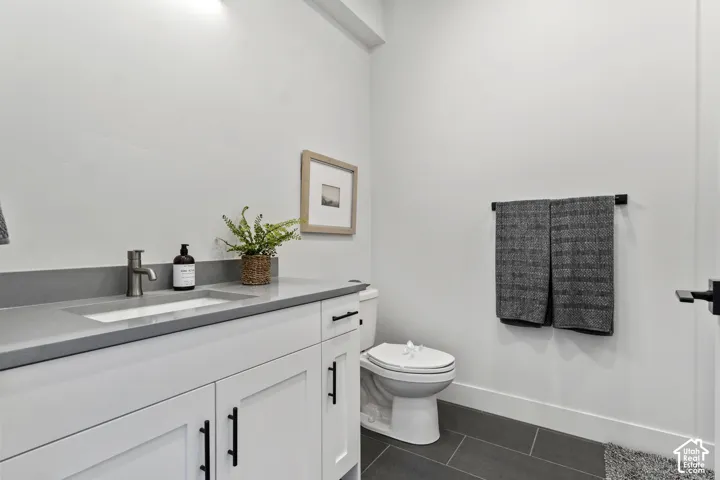 White vanity with matte black hardware, integrated sink, and gray countertop Pictures are of the model home