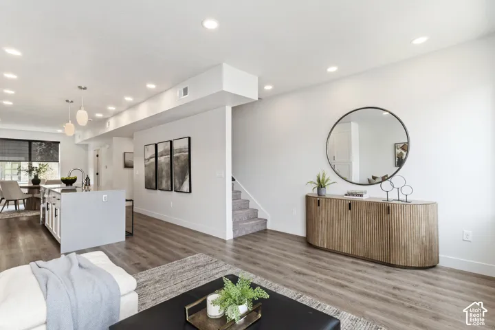 Recessed lighting, wood-finish flooring, white walls, kitchen island with integrated sink, and pendant lighting Pictures are of the model home