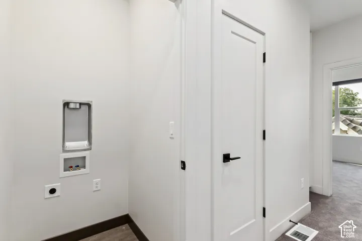 Dedicated laundry area with hookups and wood-finish flooring