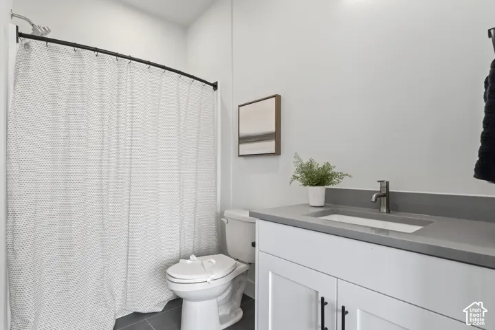 Built-in vanity with an integrated sink and countertop, white cabinetry with matte black hardware, and a shower with a curved rod Pictures are of the model home