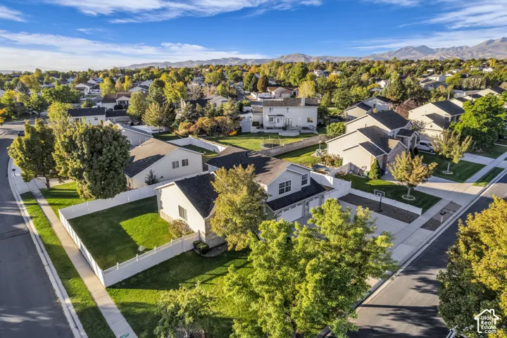 Expansive residential area featuring numerous detached homes with pitched roofs, mature trees, and manicured lawns