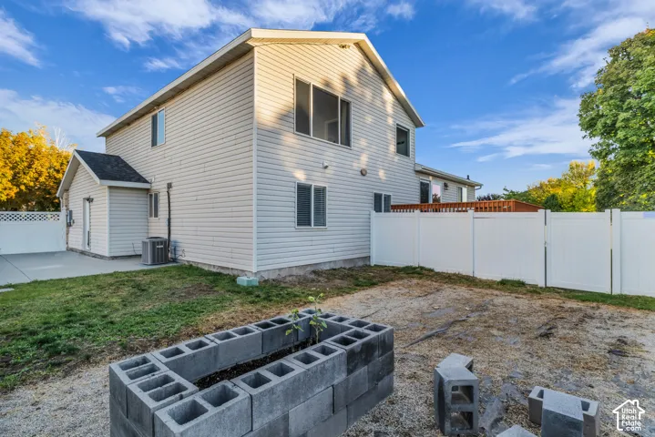 Rear exterior RV or toy parking behind white privacy fencing, separate garden spot next to shed.