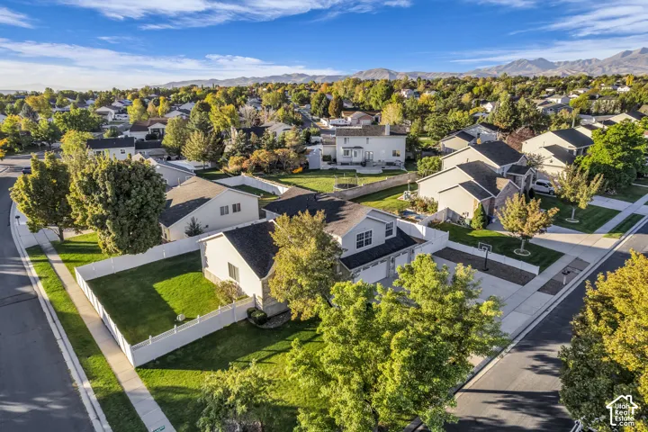 Residential neighborhood featuring mature trees and mountain scenery